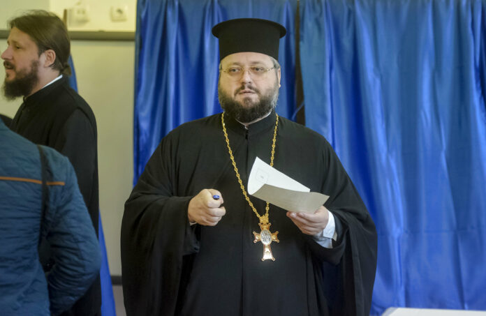 A priest exits a voting booth Saturday in Bucharest, Romania. Photo: Andreea Alexandru / Associated Press
