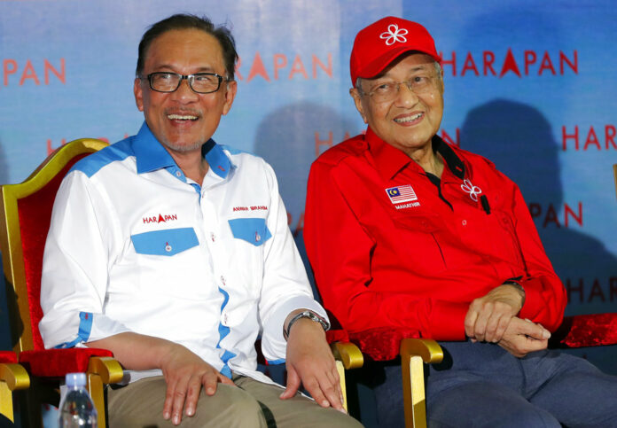 Malaysia's Prime Minister Mahathir Mohamad, right, sits next to Malaysia's reform icon Anwar Ibrahim during a Monday rally in Port Dickson. Photo: Vincent Thian / Associated Press