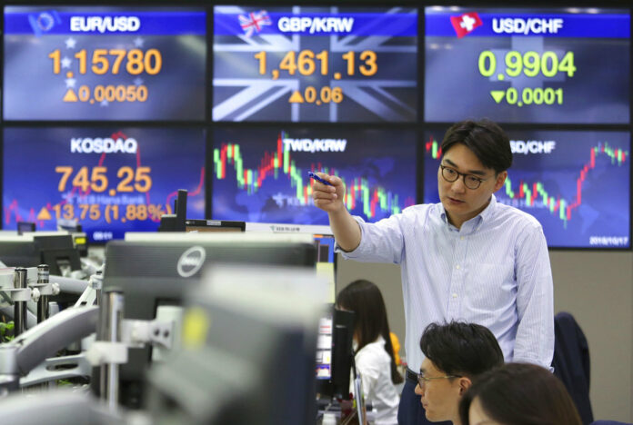 A currency trader gestures at the foreign exchange dealing room of the KEB Hana Bank headquarters Wednesday in Seoul, South Korea. Photo: Ahn Young-joon / Associated Press