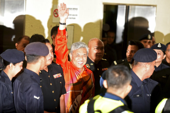 United Malays National Organization's (UMNO) Pexresident Ahmad Zahid Hamidi waves as he walks into courtroom Friday at Kuala Lumpur High Court in Kuala Lumpur, Malaysia. Photo: Yam G-Jun / Associated Press