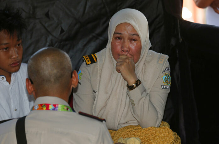 A relative of a passenger of a Lion Air plane cries while waiting for update on the plane that crashed off Java Island, at Tanjung Priok Port in Jakarta, Indonesia. Photo: Tatan Syuflana / Associated Press