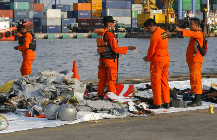 Members of Indonesian Search and Rescue Agency (BASARNAS) inspect debris recovered Monday from near the waters where a Lion Air passenger jet crashed, at Tanjung Priok Port in Jakarta, Indonesia. Photo: Tatan Syuflana / Associated Press