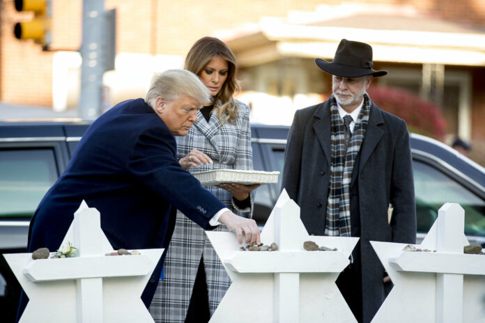 From left, President Donald Trump, accompanied by first lady Melania Trump, and Tree of Life Rabbi Jeffrey Myers, puts down a stone from the White House on Tuesday at a memorial for those killed at the Tree of Life Synagogue in Pittsburgh. Photo: Andrew Harnik / Associated Press