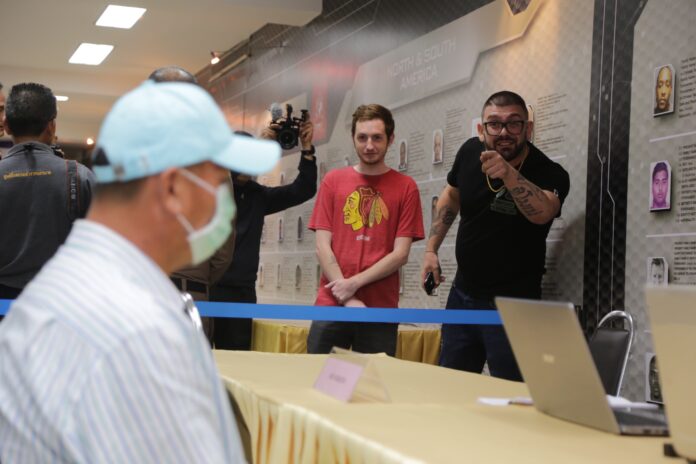 Victims point at Pairoj Kanchanarat, left, at a Thursday police press briefing in Bangkok.