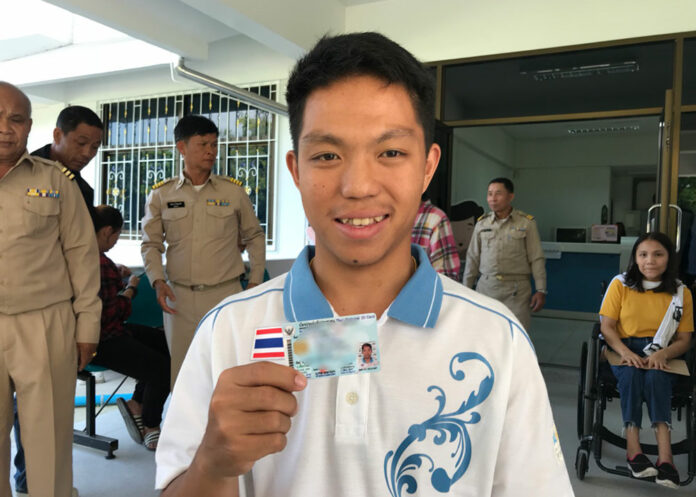 Mong Tongdee smiles while holding his Thai ID card Friday at the Chiang Mai City district office.