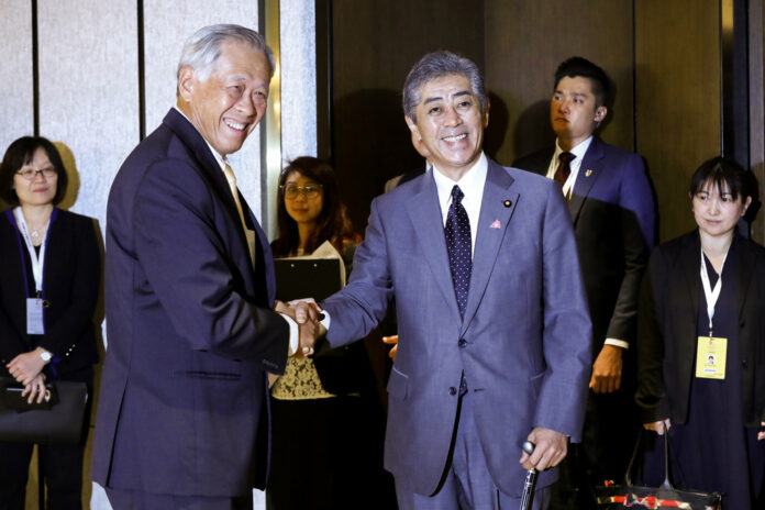 Singapore Defense Minister Ng Eng Hen greets Japan Defense Ministe Takeshi Iwaya at the ASEAN and Japanese Defense Ministers' Informal Meeting at the 12th ASEAN Defense Ministers' Meeting in Singapore on Saturday. Photo: Don Wong / Associated Press