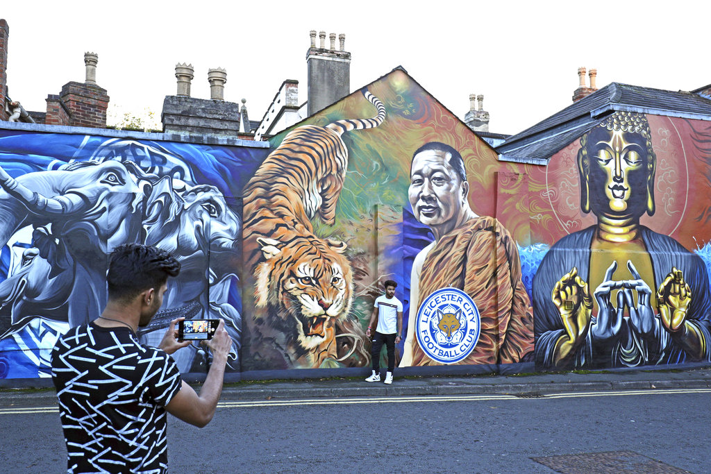 A man takes a photo Sunday near a mural of Leicester City's owner, Thai billionaire Vichai Srivaddhanaprabha near the Leicester City Football Club. Photo: Aaron Chown / PA