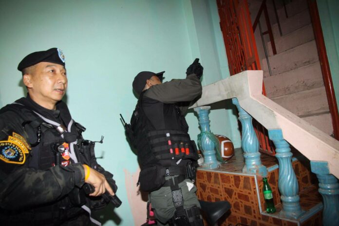 Police commandos conduct a raid on a suspected drug dealer home in Bangkok on June 1, 2016.
