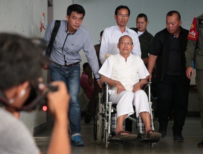 Suwit Thongprasert, on wheelchair, leaves the court on Monday.