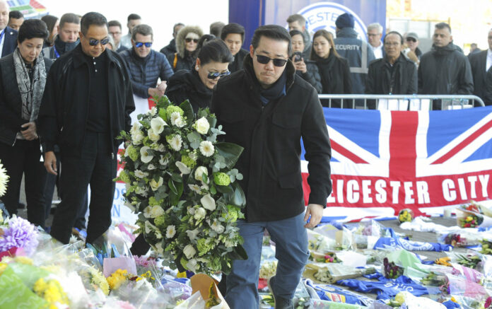 Aiyawatt Srivaddhanaprabha, the son of Vichai Srivaddhanaprabha, and his mother Aimon, center left, lay a wreath Monday with family members outside Leicester City Football Club, Leicester, England. Photo: Rui Vieira / Associated Press