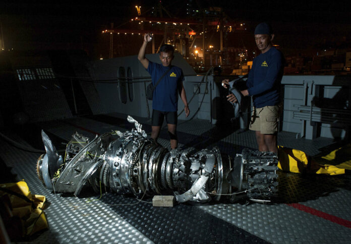 Navy divers inspect Saturday what is believed to be engine of the crashed Lion Air jet after it was retrieved from the sea floor, at Tanjung Priok Port in Jakarta, Indonesia. Photo: Fauzy Chaniago / Associated Press