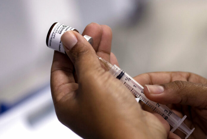 A health worker prepares a syringe with a vaccine against measles in August in Rio de Janeiro, Brazil. Photo: Leo Correa / Associated Press