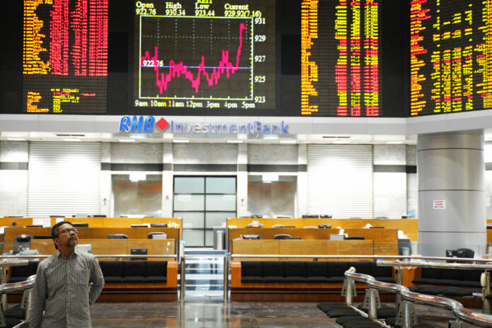 An investor walks in front of private stock trading boards in November at a private stock market gallery in Kuala Lumpur, Malaysia. Photo: Yam G-Jun / Associated Press