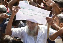 Bangladesh Scraps Rohingya Return, Says No One Wants to Go An elderly Rohingya refugee holds a placard Thursday during a protest against the repatriation process at Unchiprang refugee camp near Cox's Bazar, in Bangladesh. Photo: Dar Yasin / Associated Press
