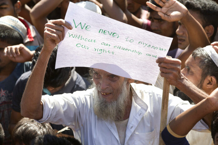 An elderly Rohingya refugee holds a placard Thursday during a protest against the repatriation process at Unchiprang refugee camp near Cox's Bazar, in Bangladesh. Photo: Dar Yasin / Associated Press