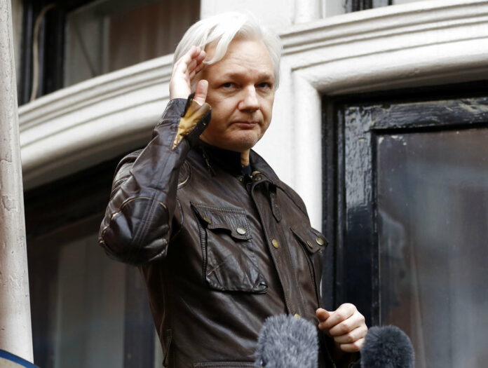 In this May 19, 2017, file photo, WikiLeaks founder Julian Assange greets supporters from a balcony of the Ecuadorian embassy in London. Photo: Frank Augstein / Associated Press