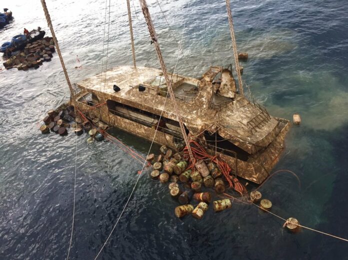 In this photo taken and released by the Thailand Phuket Public Affairs Office, Saturday, Nov. 17, 2018, the tour boat named the Pheonix is raised from the sea floor after sinking over four months ago in rough weather killing 47 tourists. Photo: Phuket Public Affairs Office via AP