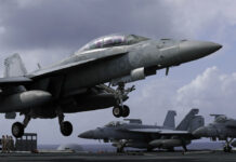 US Carrier in Hong Kong After Bombers Fly Over S. China Sea An F/A-18 Super Hornet fighter jet lands Tuesday on the deck of the U.S. Navy USS Ronald Reagan in the South China Sea. Photo: Kin Cheung / Associated Press