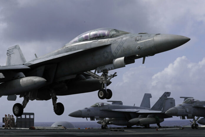 An F/A-18 Super Hornet fighter jet lands Tuesday on the deck of the U.S. Navy USS Ronald Reagan in the South China Sea. Photo: Kin Cheung / Associated Press