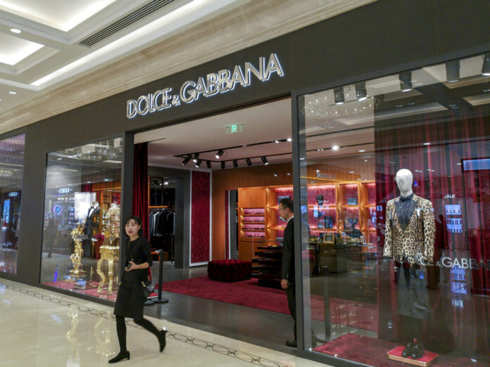 A woman walks out of an outlet of Dolce&Gabbana in Shanghai, China Wednesday Nov. 21, 2018. Photo: Chinatopix Via AP