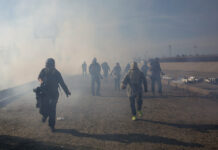 Trump Backs Use of ‘Very Safe’ Tear Gas on Crowd of Migrants Migrants run from tear gas launched by U.S. agents, amid photojournalists covering the Mexico-U.S. border, after a group of migrants got past Mexican police at the Chaparral crossing Sunday in Tijuana, Mexico. Photo: Rodrigo Abd / Associated Press