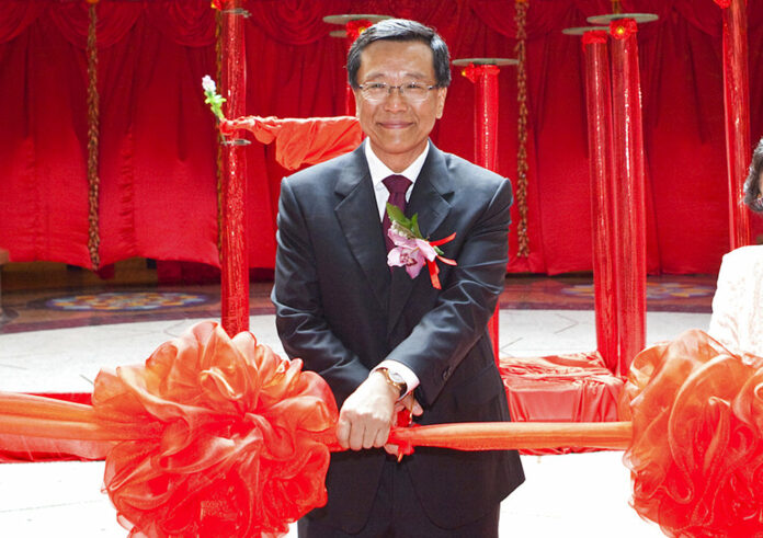 Chairman of the Malaysian Genting Group developer Tan Sri Lim Kok Thay cuts a ceremonial ribbon to open a casino in Singapore. Photo: Joan Leong / Associated Press