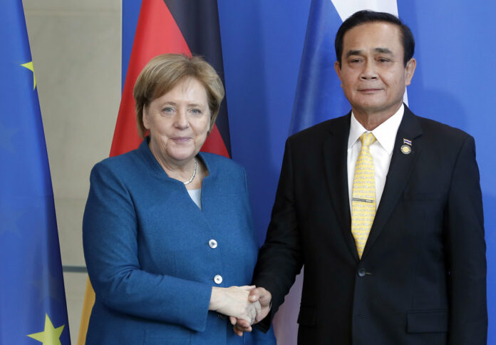 German Chancellor Angela Merkel, left, and Thailand's Prime Minister Prayut Chan-o-cha, right, shake hands Wednesday after a joint statement at the chancellery in Berlin, Germany. Photo: Michael Sohn / Associated Press