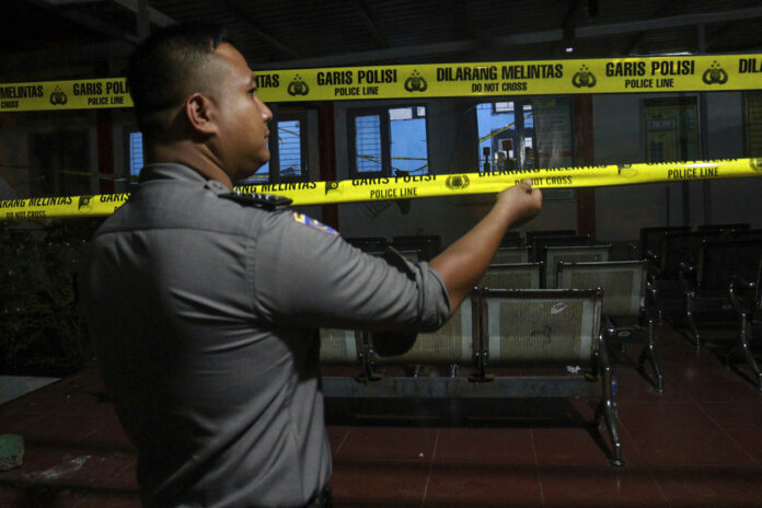 A police officer puts up police lines Thursday outside Lambaro Prison following a jailbreak in Aceh Besar, Indonesia. Photo: Hendri Abik / Associated Press