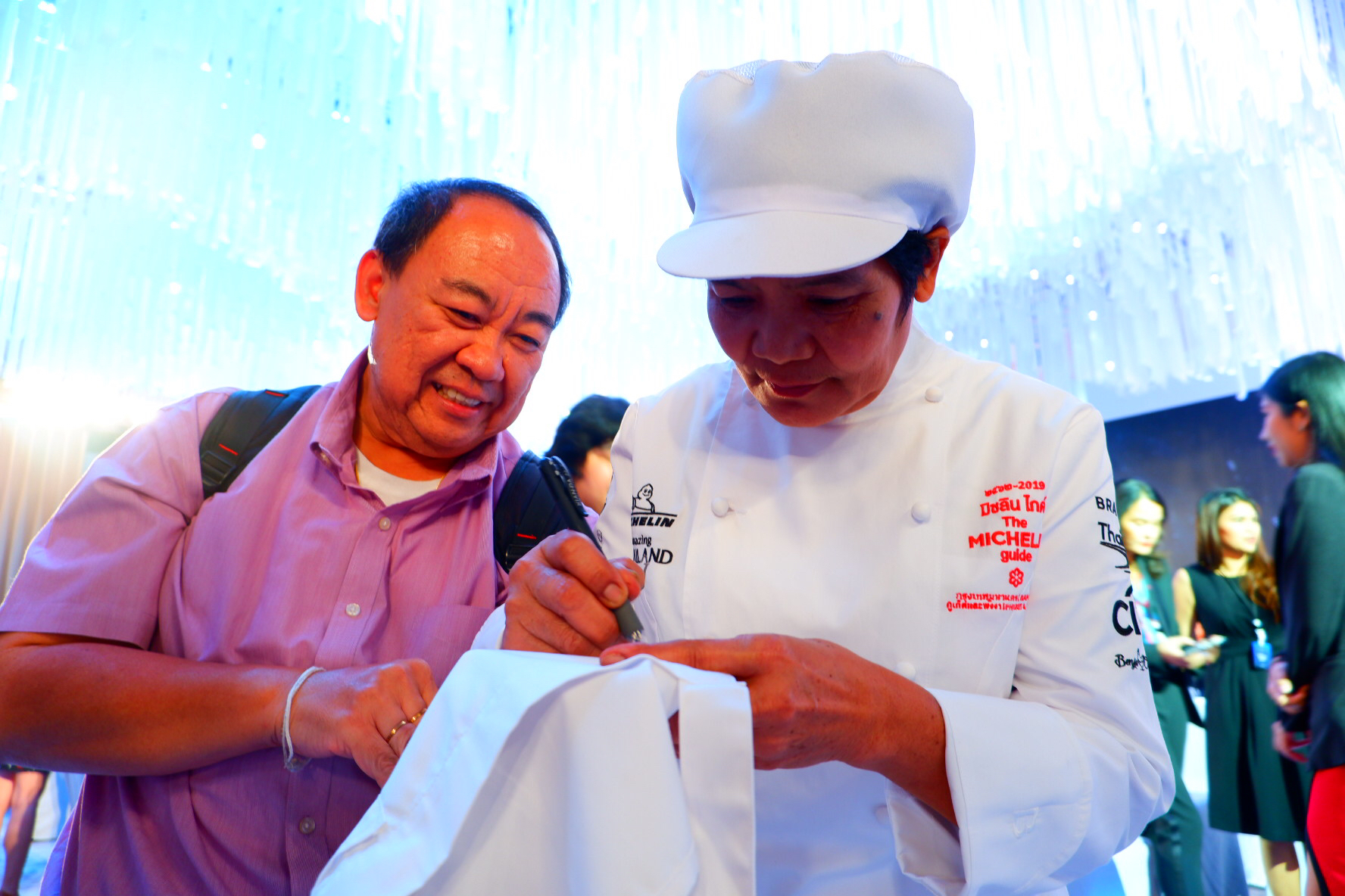 Banyen signs a chef’s jacket for a fan. 