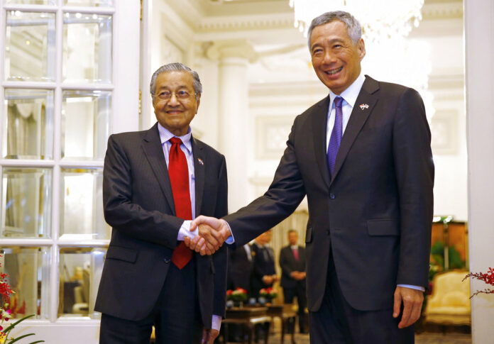 Malaysia's Prime Minister Mahathir Mohamad, at left, shakes hands with Singapore's Prime Minister Lee Hsien Loong on Monday at the Istana in Singapore. Photo: Feline Lim / Pool photo via AP