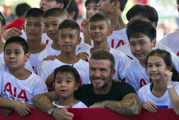 Retired footballer David Beckham poses Saturday for a group photograph during a sponsored promotional event in Bangkok. Photo: Gemunu Amarasinghe / Associated Press