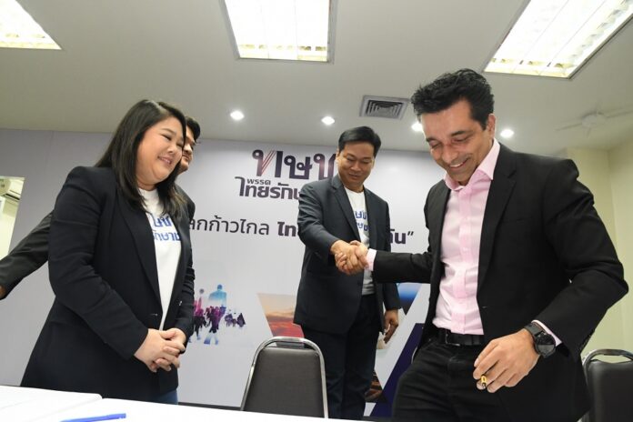 Former Bangkok Post editor Umesh Pandey, right, signs up with Thai Raksa Chart Party on Wednesday.