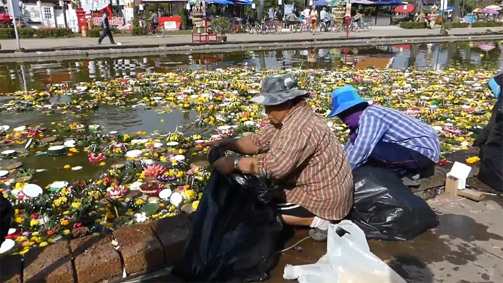 Workers clean up krathongs from a pond in the Sukhothai Historical Park.