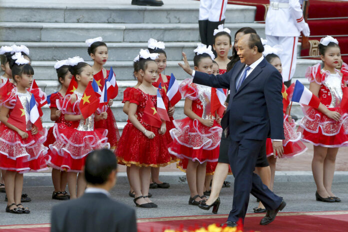 Vietnamese Prime Minister Nguyen Xuan Phuc waves to children on Nov. 2 outside the Presidential Palace in Hanoi. Photo: Minh Hoang / Pool photo via AP