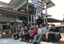 Democracy Activists Intercepted En Route to Rajabhakti Park Sirawith “Ja New” Seritiwat, third from right, sits with his supporters Sunday in front of Khao Yoi police station in Phetchaburi province.
