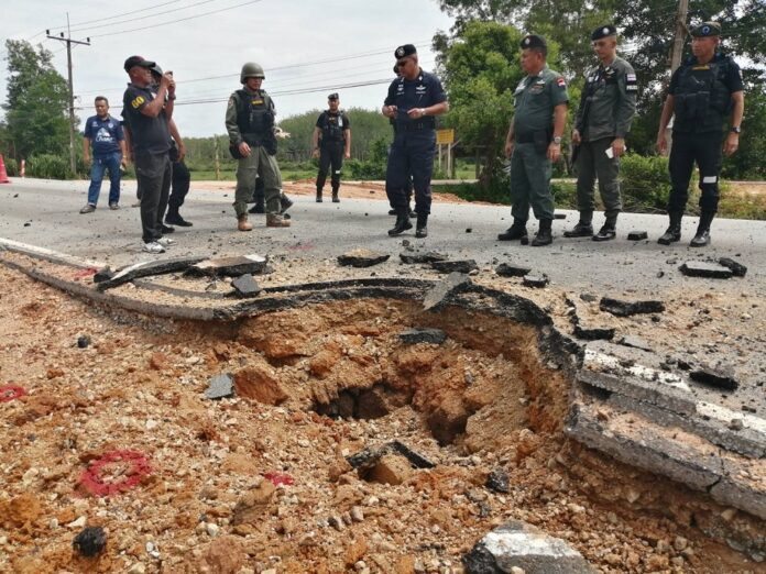 Security officers on Saturday inspect the site of a roadside bombing in Narathiwat province.