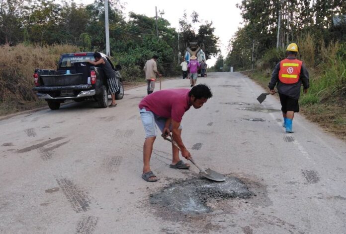 Baan Noi residents repair a stretch of road Saturday.