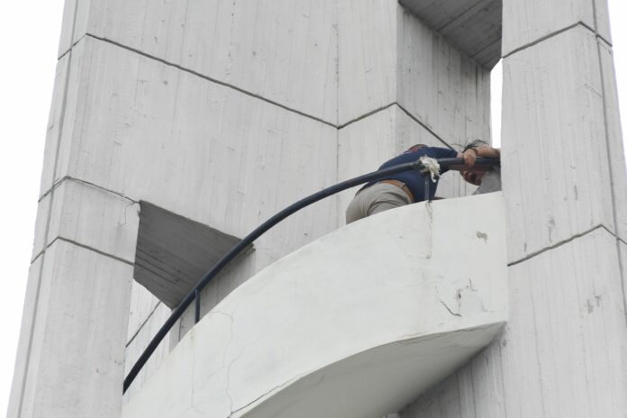 A rescue worker grapples with a woman who threatened to jump from a water tower Friday on Thammasat University’s Tha Prachan campus. A rescue worker grapples with a woman who threatened to jump from a water tower Friday on Thammasat University’s Tha Prachan campus.