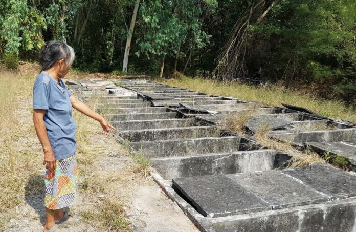 A local resident stands Saturday near broken tombs in Rayong province where 15 stillborn babies were reportedly missing. A local resident stands Saturday near broken tombs in Rayong province where 15 stillborn babies were reportedly missing.