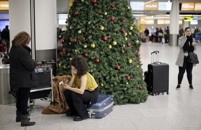 People wait in the departures area at Gatwick airport, near London, as the airport remains closed with incoming flights delayed or diverted to other airports, after drones were spotted over the airfield last night and this morning, Thursday, Dec. 20, 2018. (AP Photo/Tim Ireland)