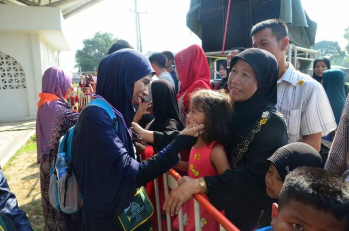 A southern Thai woman says goodbye to her family July 24, 2017, before leaving for hajj.
