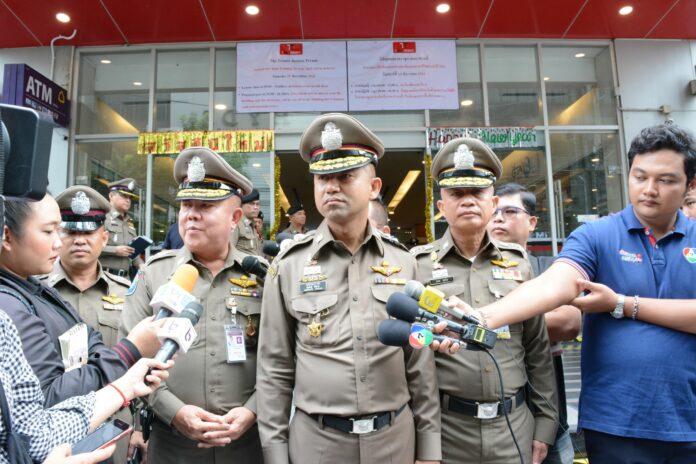Flanked by two senior officers, Maj. Gen. Surachate Hakparn speaks to reporters at the scene where a French national was shot to death by a Bangkok police officer.