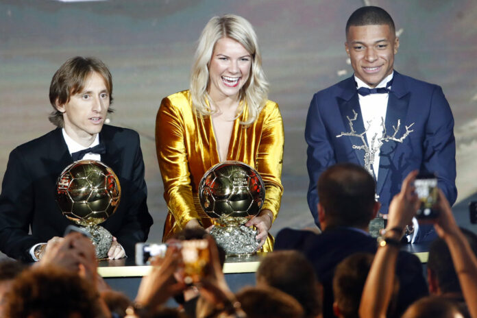 Olympique Lyonnais' Ada Hegerberg with the Women's Ballon d'Or, center, poses with Real Madrid's Luka Modric, with the Ballon d'Or, left, and Paris St Germain's Kylian Mbappe with the Kopa Trophy, right, during the Golden Ball award ceremony Monday at the Grand Palais in Paris, France. Photo: Christophe Ena / Associated Press