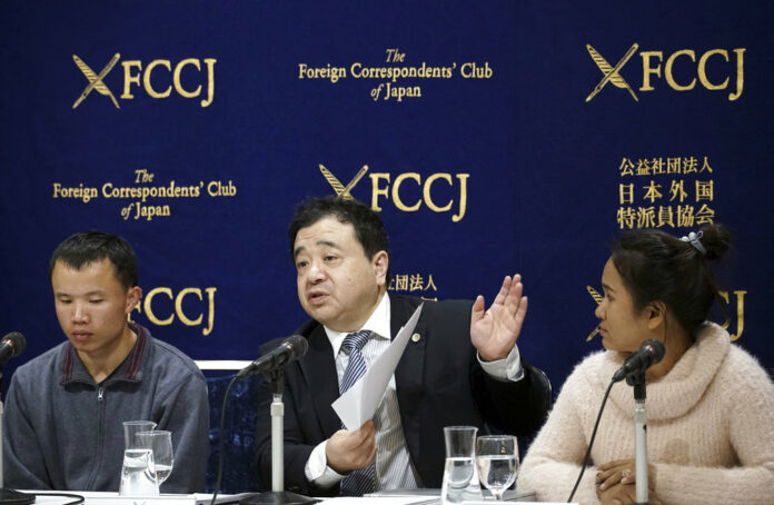 Lawyer Shoichi Ibusuki, center, speaks in November during a press conference in Tokyo, on the problems in Japan's technical intern program, with Eng Pisey, right, Cambodian technical trainee and Huang Shihu, left, Chinese technical trainee in Tokyo. Photo: Eugene Hoshiko / Associated Press