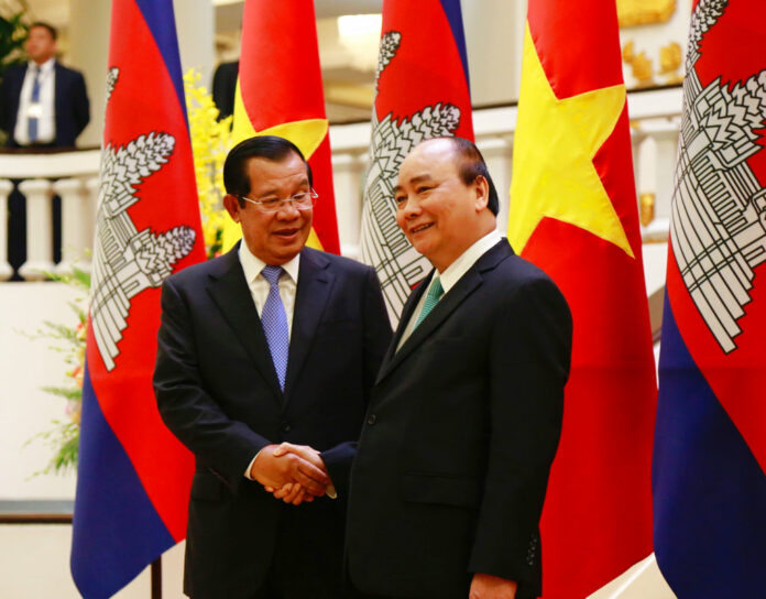 Cambodian Prime Minister Hun Sen, left, shakes hands Friday with his Vietnamese counterpart Nguyen Xuan Phuc before heading for talks behind closed doors in Hanoi, Vietnam. Photo: Tran Van Minh / Associated Press