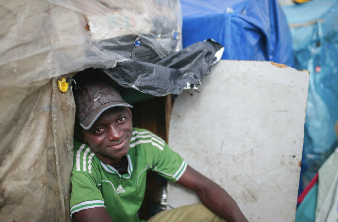 Wazzizi, a sub-Saharan migrant from Guinea, sits Thursday outside the tent where he lives at at Ouled Ziane camp in Casablanca, Morocco. Photo: Mosa'ab Elshamy / Associated Press