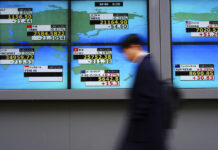 Asian Shares Mixed on Concerns Over Trade, Economic Outlook A man walks Tuesday past an electronic stock board showing Japan's Nikkei 225 and other country's index at a securities firm in Tokyo. Photo: Eugene Hoshiko / Associated Press