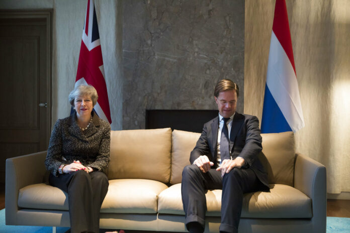 British Prime Minister Theresa May, left, and Dutch Prime Minister Mark Rutte pose for photographers at the start of a meeting Tuesday in The Hague, Netherlands. Photo: Peter Dejong / Associated Press