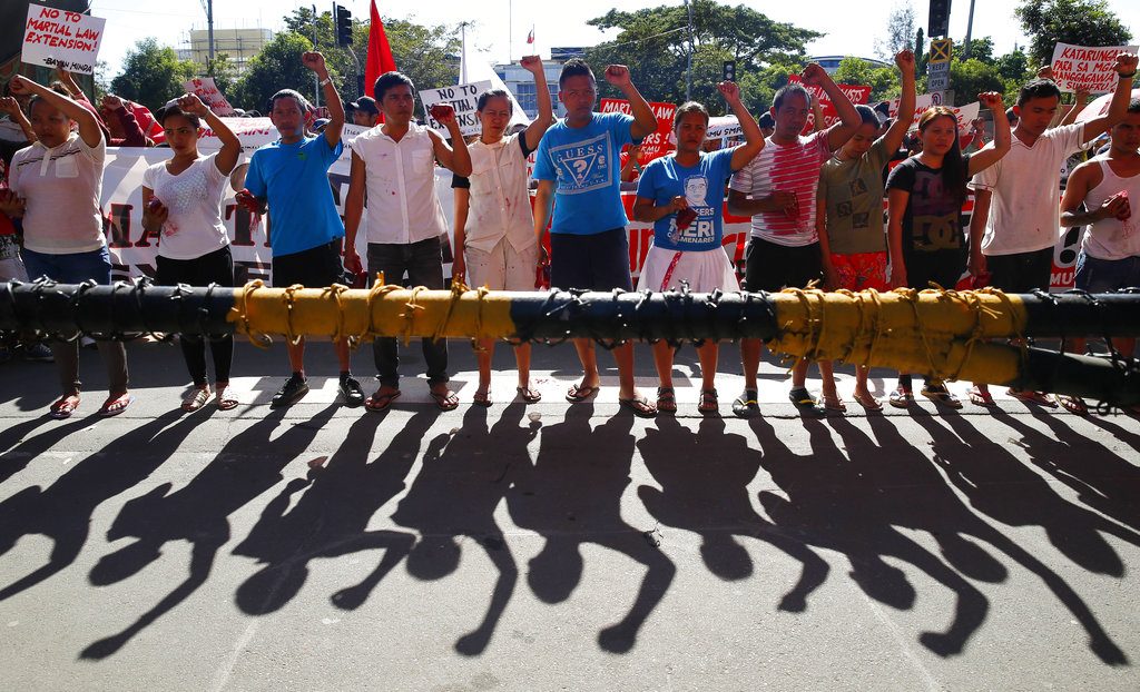 Protesters clench their fists Wednesday during a rally at the Lower House to coincide with the joint Senate and Congress vote for the third extension of martial law in southern Philippines in suburban Quezon city, northeast of Manila, Philippines. Photo: Bullit Marquez / Associated Press