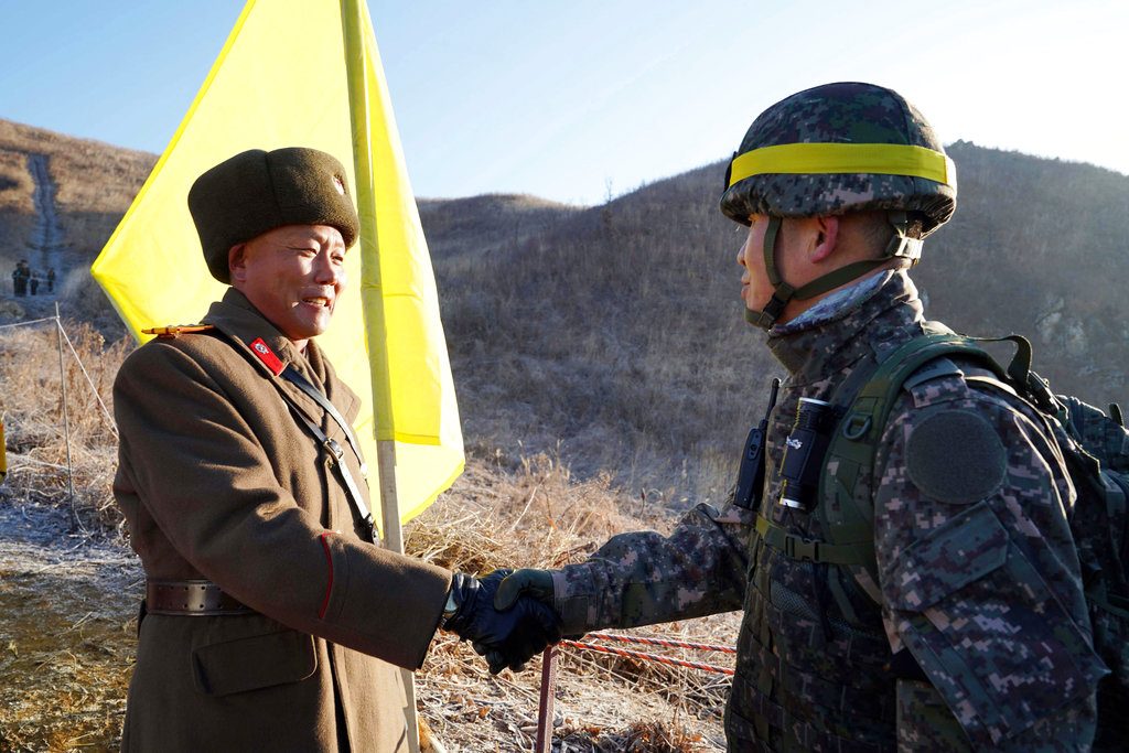 South Korean army Col. Yun Myung-shick, right, shakes hands Wednesday with North Korean army Lt. Col. Ri Jong Su before crossing the Military Demarcation Line inside the Demilitarized Zone (DMZ) to inspect the dismantled North Korean guard post in the central section of the inter-Korean border in Cheorwon. Photo: Associated Press